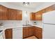Bright kitchen featuring wood cabinets, stainless steel microwave, white appliances, and a modern faucet at 2393 E 90Th Ave, Thornton, CO 80229
