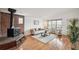 Cozy living room featuring hardwood floors, brick fireplace, and large window for natural light at 2393 E 90Th Ave, Thornton, CO 80229