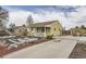 Single-story home showing the side yard, driveway, and landscaped garden with white trim and charming curb appeal at 1254 S Osceola St, Denver, CO 80219