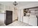 Kitchen with white cabinets, black fridge, washer and dryer at 1254 S Osceola St, Denver, CO 80219