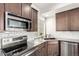 Modern kitchen features stainless steel appliances, granite countertops, and sleek subway tile backsplash at 18639 E 50Th Pl, Denver, CO 80249