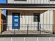 Modern home's blue front door with black metal railing at 3880 Sheridan Blvd, Denver, CO 80212