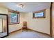 Finished basement with two windows, neutral carpet, baseboard trim, and a dark wood door at 4545 King St, Denver, CO 80211