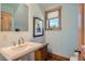 Charming bathroom with a pedestal sink, wooden accents, and a window for natural light at 4545 King St, Denver, CO 80211