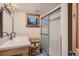 Neutral bathroom with subway tiled shower, patterned floors, sink, vanity, and wood trim window at 4545 King St, Denver, CO 80211