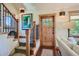 Bright entryway featuring stairs with wooden railings and a rustic wooden front door with glass panels at 4545 King St, Denver, CO 80211