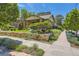 Charming home featuring a beautifully landscaped front yard with a unique stone retaining wall and lush greenery at 4545 King St, Denver, CO 80211