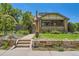 Brick home featuring stone retaining wall, manicured lawn and a pathway leading to the front door at 4545 King St, Denver, CO 80211