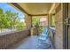 Inviting covered front porch with brick surround and metal railing, offering a charming outdoor seating area at 4545 King St, Denver, CO 80211