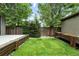 Backyard featuring a small deck area and a small patch of grass with planter boxes and fence at 2077 S Clayton St, Denver, CO 80210