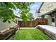 Backyard features a wood fence, planter boxes, small grass area, and string lights above at 2077 S Clayton St, Denver, CO 80210