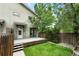 Backyard with a patio, steps, grass and trees with string lights on the back of the house at 2077 S Clayton St, Denver, CO 80210