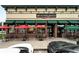 Bruegger's Bagels exterior with red brick, green awnings, and outdoor seating at 2077 S Clayton St, Denver, CO 80210