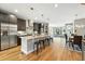 Modern kitchen with stainless steel appliances, a granite island with seating, and an open floor plan to the living room at 2077 S Clayton St, Denver, CO 80210