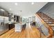Open-concept kitchen with dark wood cabinets, a large island with seating, and a view of the dining and living rooms at 2077 S Clayton St, Denver, CO 80210