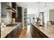 Modern kitchen featuring stainless steel appliances, granite countertops, dark wood cabinets, and hardwood floors at 2077 S Clayton St, Denver, CO 80210