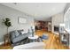 Open-concept living room with hardwood floors, a stone fireplace, and a view of the dining room and kitchen at 2077 S Clayton St, Denver, CO 80210