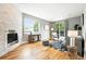 Bright living room with a stone fireplace, hardwood floors, large windows, and sliding glass doors to the backyard at 2077 S Clayton St, Denver, CO 80210