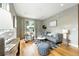 Comfortable living room with hardwood floors, neutral paint colors, a modern sofa, and a large window at 2077 S Clayton St, Denver, CO 80210