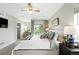 Bright main bedroom featuring a ceiling fan, neutral decor, and a large window overlooking the neighborhood at 2077 S Clayton St, Denver, CO 80210