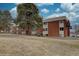 Brick building with outside staircase on a grass lawn with mature trees at 3633 S Sheridan Blvd # S4, Denver, CO 80235