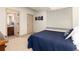 Cozy bedroom shows ensuite bathroom, a dark blue quilt and a window with blinds at 15798 Weaver Gulch Dr, Morrison, CO 80465