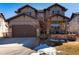 Charming two-story home featuring a stone-accented facade, inviting front porch, and a spacious two-car garage at 15798 Weaver Gulch Dr, Morrison, CO 80465