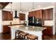 Modern kitchen featuring dark wood cabinets, granite countertops, a large island, and stainless steel appliances at 15798 Weaver Gulch Dr, Morrison, CO 80465