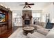 Warm living room with stone fireplace, comfortable seating, ceiling fan, and natural light from the windows at 15798 Weaver Gulch Dr, Morrison, CO 80465