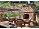 Cozy outdoor stone fireplace surrounded by comfortable wicker seating, perfect for entertaining at 15798 Weaver Gulch Dr, Morrison, CO 80465
