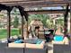 Spacious outdoor patio featuring comfortable seating, a dining table, and a stone fireplace, ideal for gatherings at 15798 Weaver Gulch Dr, Morrison, CO 80465