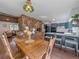 Cozy dining room with stone accent wall, open to kitchen with blue cabinets and an adjacent living room area at 30858 Niakwa Rd, Evergreen, CO 80439