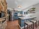 Modern kitchen with dark blue cabinets, a stainless steel refrigerator, and a tiled island at 30858 Niakwa Rd, Evergreen, CO 80439