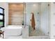 Bright bathroom featuring a soaking tub, glass-enclosed shower, and designer tile at 2960 E Floyd Dr, Denver, CO 80210