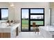 Bright bathroom featuring marble countertops, modern fixtures, an oversized window, and a free-standing bathtub at 2960 E Floyd Dr, Denver, CO 80210