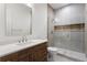 Modern bathroom featuring a sleek vanity with stone countertop and a glass-enclosed shower with neutral tile at 2960 E Floyd Dr, Denver, CO 80210
