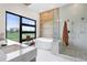 Bright bathroom featuring modern fixtures, an oversized window, and a glass shower at 2960 E Floyd Dr, Denver, CO 80210
