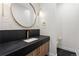 Stylish half bathroom with a textured wall, gold fixtures, and modern sink at 2960 E Floyd Dr, Denver, CO 80210