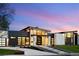 Striking modern home featuring unique architecture, stone accents, and large windows at sunset at 2960 E Floyd Dr, Denver, CO 80210