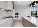 Modern kitchen with stone countertops, stainless steel appliances, designer lighting, and wood floors at 2960 E Floyd Dr, Denver, CO 80210