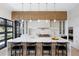 Gourmet kitchen featuring a large center island, marble backsplash, and designer pendant lighting at 2960 E Floyd Dr, Denver, CO 80210