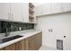 Well-organized laundry room with custom cabinetry and quartz countertops at 2960 E Floyd Dr, Denver, CO 80210