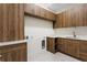 Well-organized laundry room features matching wood cabinets with stylish hardware, ample storage, and a modern sink at 2960 E Floyd Dr, Denver, CO 80210