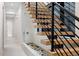 Modern staircase with wooden treads, black railings, and a decorative planter at 2960 E Floyd Dr, Denver, CO 80210