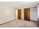 Bedroom with neutral carpet and walls and a view of a closet with wooden doors at 1816 S Pagosa Way # 5, Aurora, CO 80017