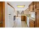 Bright kitchen with a skylight, white appliances, wooden cabinets, and a view into the dining area at 1816 S Pagosa Way # 5, Aurora, CO 80017
