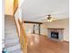 View of a spacious living room featuring hardwood floors, brick fireplace, and a staircase at 1816 S Pagosa Way # 5, Aurora, CO 80017