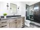 Modern bathroom featuring a stylish vanity, black fixtures, and a glass-enclosed shower with dark tile surround at 1685 S Milwaukee St, Denver, CO 80210