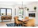 Elegant dining room with a modern chandelier, fireplace, hardwood floors, and ample natural light at 1685 S Milwaukee St, Denver, CO 80210