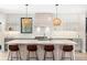 Bright, modern kitchen featuring white subway tile, a large island with seating, and stylish pendant lighting at 1685 S Milwaukee St, Denver, CO 80210
